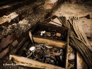 Holzschublade mit rostigem Werkzeug auf dem Boden der ehemaligen Weberei.