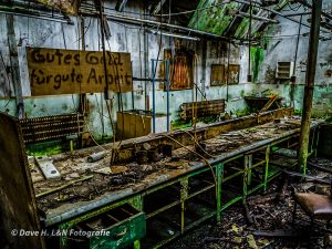 Mit Rost umhüllt steht die Werkbank an der Wand der verlassenen Produktionshalle.