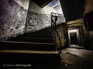 Schaurig wirkend, leicht im Dunkel, Schwingt sich eine alte Treppe in das Obergeschoss der alten Tuchfabrik.