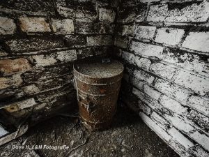 Alte Tonne überzogen von Rost in der Ecke eines Raumes