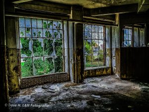 Kaputte Scheiben und eingestürzte Decken einer verlassenen Industriestätte.