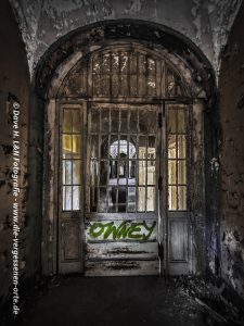 Eine große Eingangstür in dem Waldhaus Sanatorium wirkt imposant und fast wie in einem Schloss.