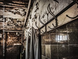 Es befinden sich verrostete Kleiderhaken in diesem verlassenen Gebäude.