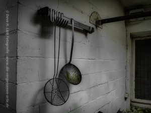 Schaumkellen hängend an der Wand der verlassenen Hotelküche.