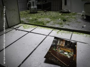 Auf dem Boden der Küche liegend, ein Foto des verlassenen Kurhotels, es Zeigt das Buffet zu seiner Blütezeit.