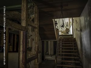 Zwischenraum von Tresen und Gastraum. Eine Treppe die hinauf zu den verlassenen Hotelzimmern führt.
