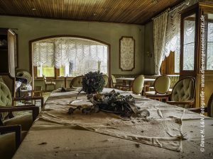 Blick über eine Tafel, durch den Gastraum hinaus zum Panoramafenster.