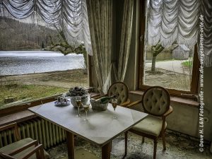 Gedeckter Tisch eines verlassenen Gasthofes mit Blick auf den See.