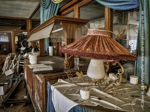 Lampe im nostalgischen DDR Stil neben dem Buffet des verlassenen Kurhotels.