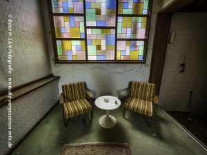 Im Aufgang zu den Zimmern, eine Ecke mit Sitzmöbeln in nostalgischem Stil.