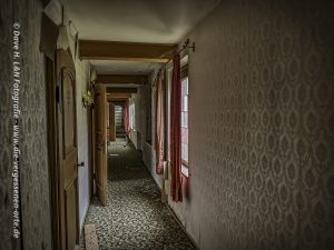 Flur des verlassenen Hotels von dem die einzelnen Zimmer abgehen.