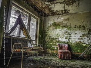 Mit Grünspan bedecktes Zimmer des verlassen Kurhotels, eingerichtet mit Sitzmöbel.