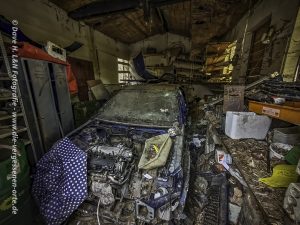 In anliegender Garage des einstigen Kurhotels ist ein verlassenes Auto.