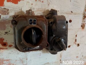 Ein Drehschalter an der Wand, überzogen von Rost und Staub, in der alten Ölmühle.