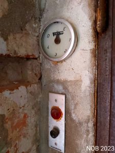 Eine Analog-Hydraulikanzeige an einer Wand zeigt den letzten Stand nach der Schließung an.