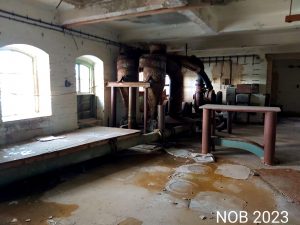 Ein großer Raum in der alten Ölmühle, hinten in der Ecke sind noch ein paar Maschinen der alten Industrie zu sehen.