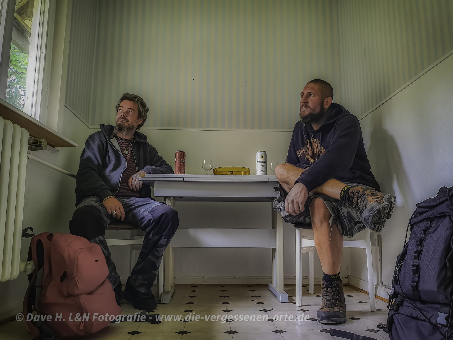 Auf Lost Place Tour: Dave und Nils sitzen an einem Tisch in einer verlassenen Pension.