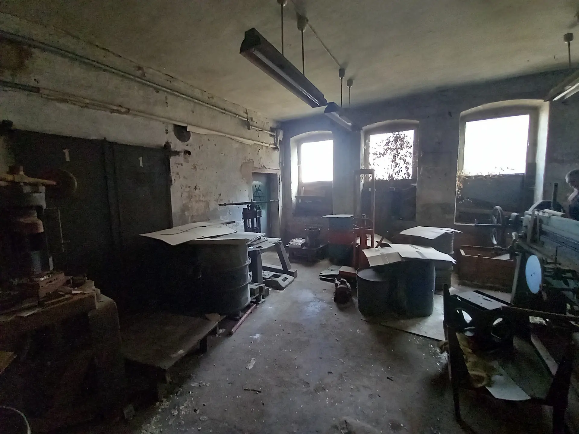 Produktionshalle der einstigen jüdischen Schuhfabrik mit Werkbänken und Arbeitsgeräten.