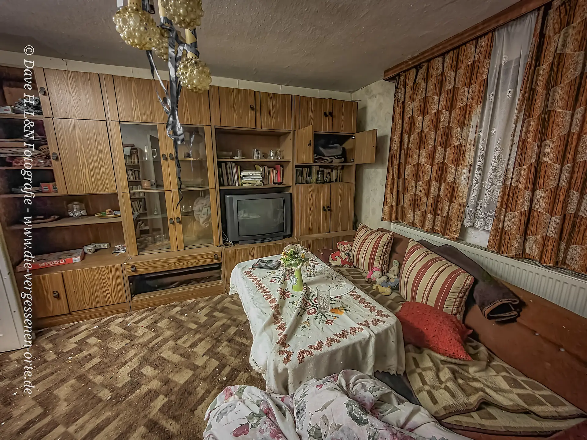 Wohnzimmer mit Einrichtung in einem verlassenen Wohnhaus.