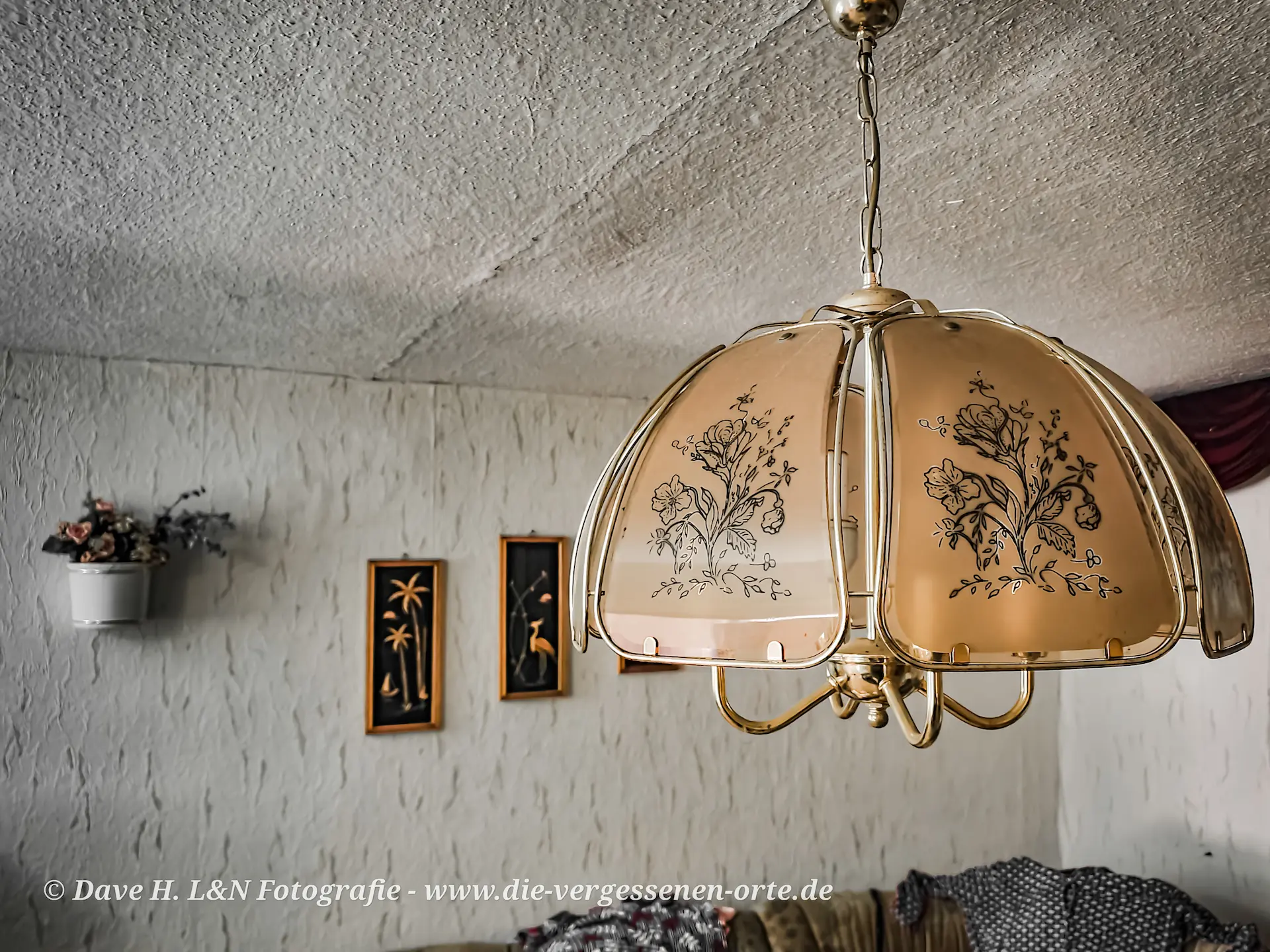 Nostalgische Lampe an der Decke des verlassenen Wohnhauses.