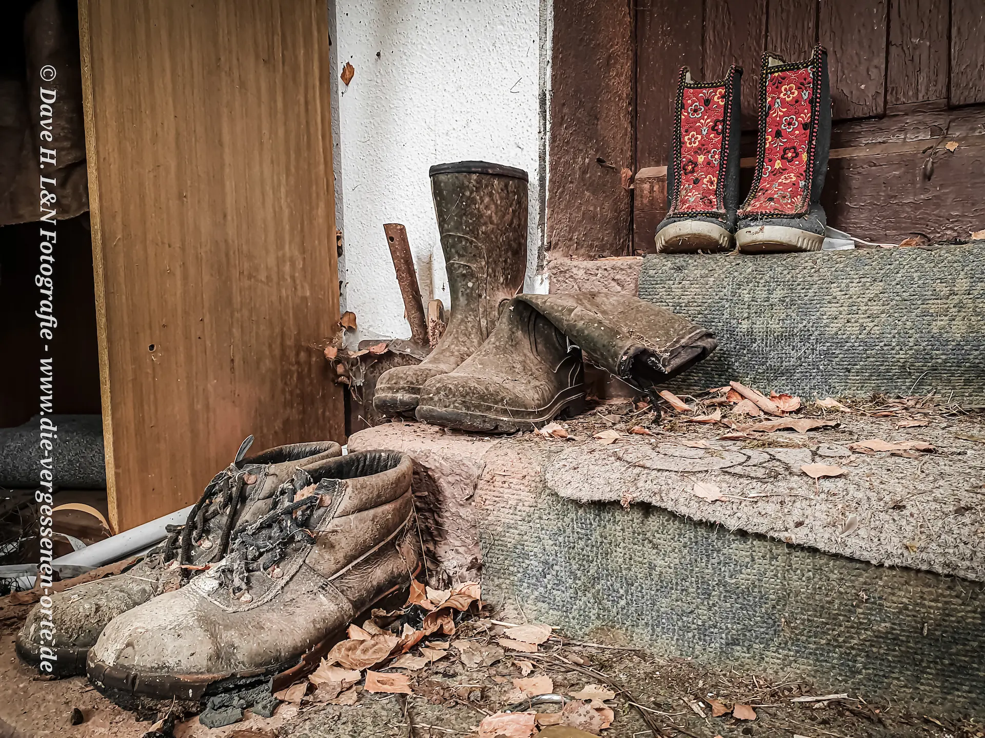 Arbeitsschuhe stehen auf der Treppe der Veranda.