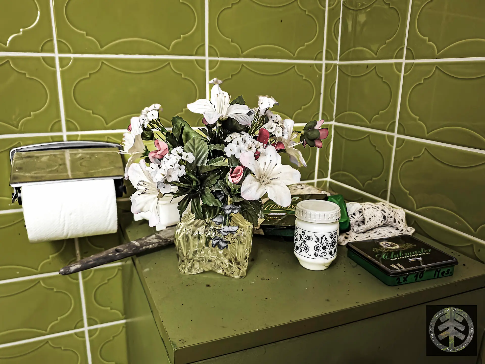 Kunstblumengesteck in der Ecke des Badezimmers.