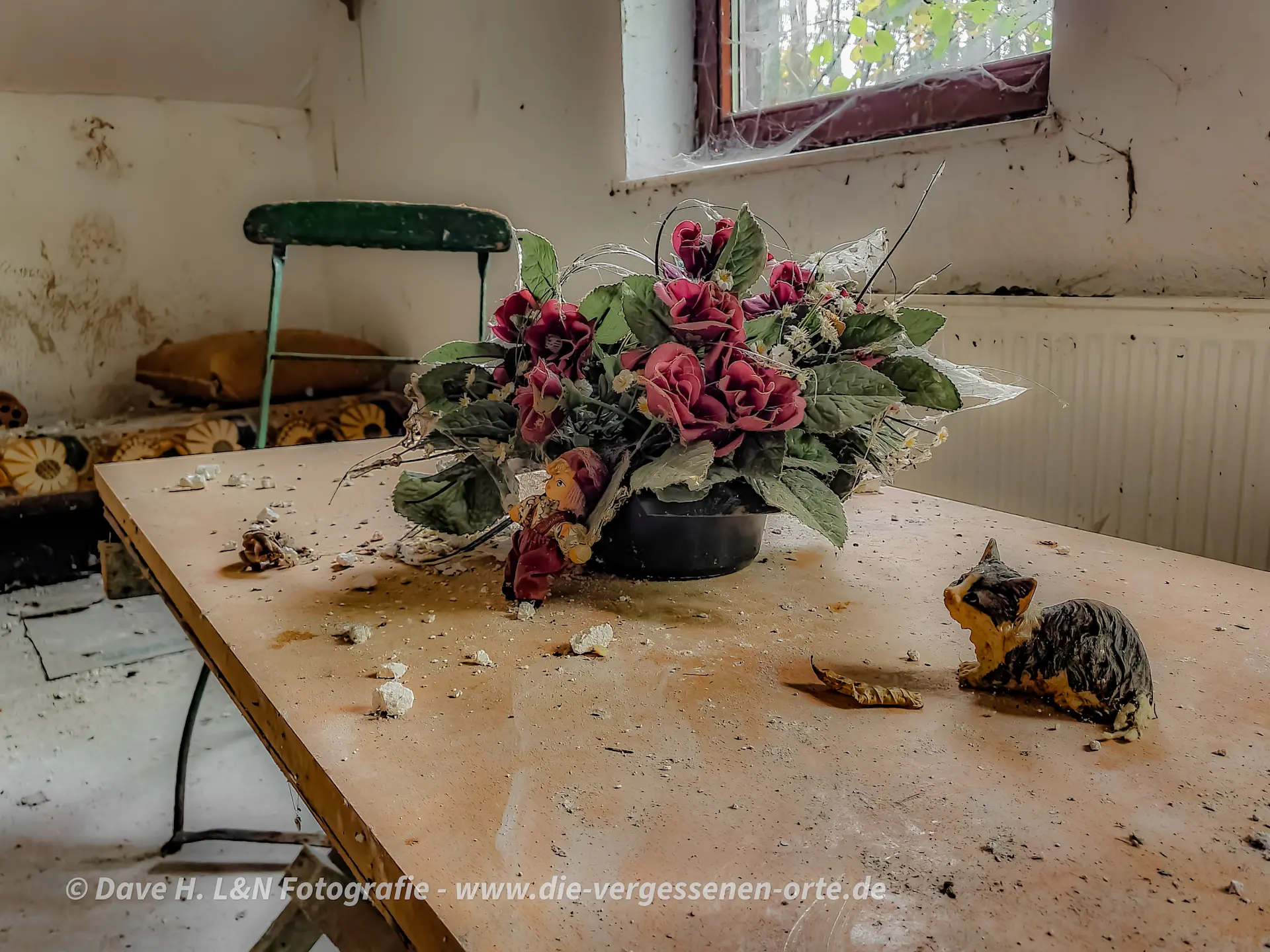 Alte Plastikblumen auf einem Tisch des Vergessenen Wohnstallhauses.