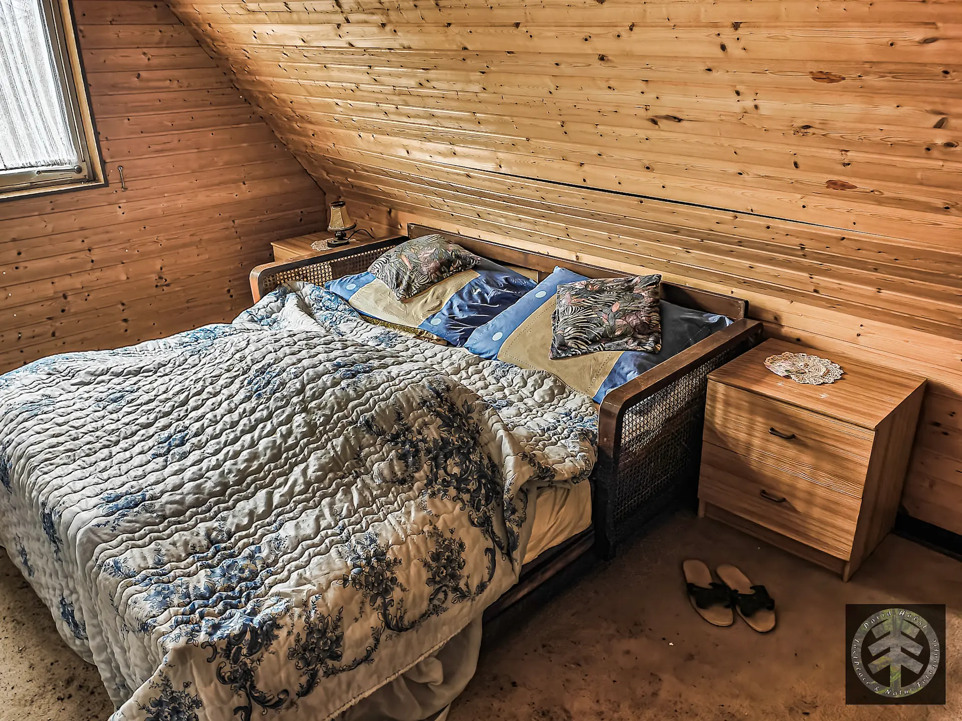 Doppelbett noch frisch bezogen im Schlafzimmer des verlassenen Wochenendhauses am See.