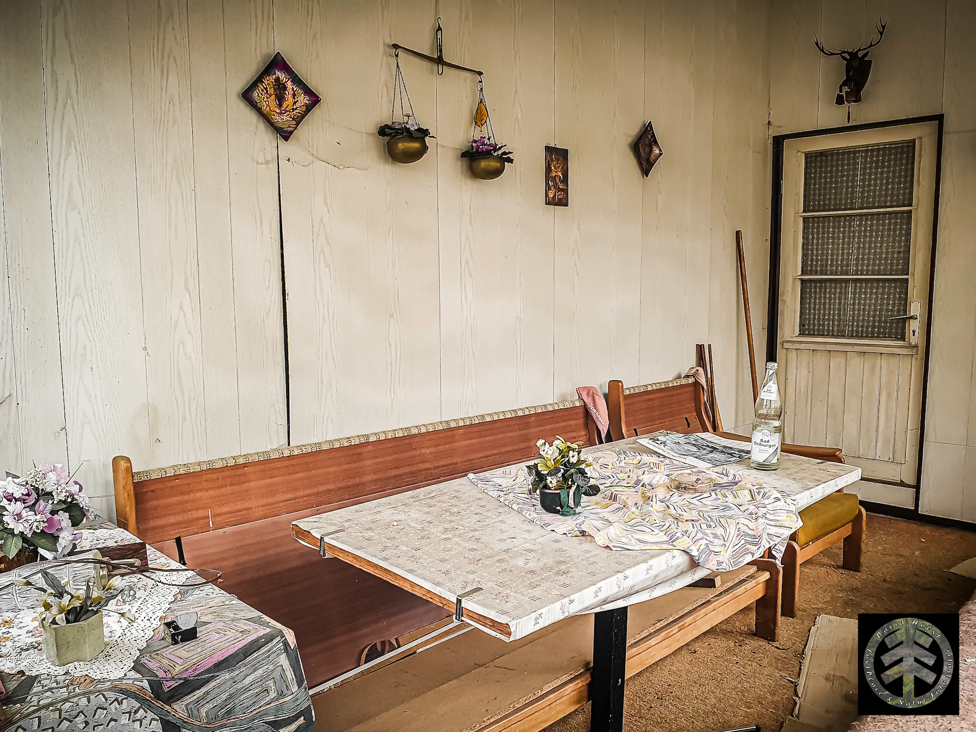 Tisch und Sitzbank in altem Stil im Aufenthaltsraum des verlassenen Wohnhauses.