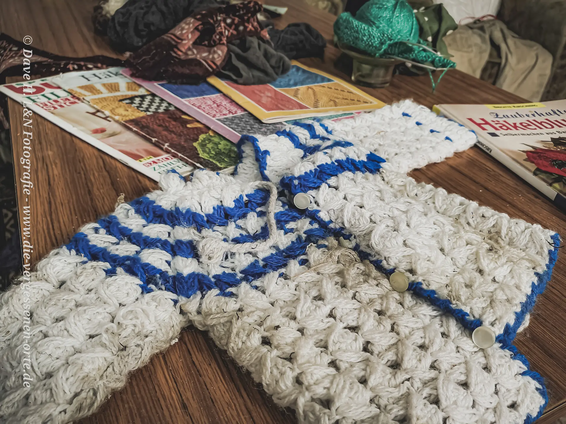 Pullover für Puppen, selbst gehäkelt. Er liegt einsam auf dem Tisch.