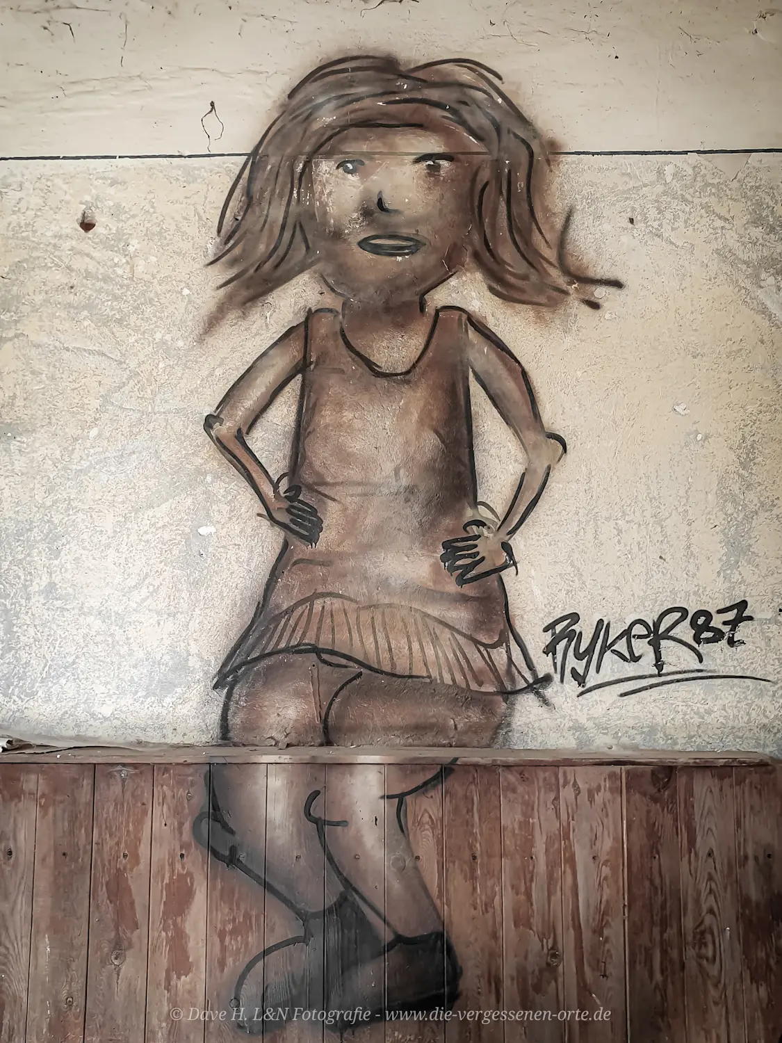 Graffiti einer Frau an einer Wand der verwaisten Anlage.
