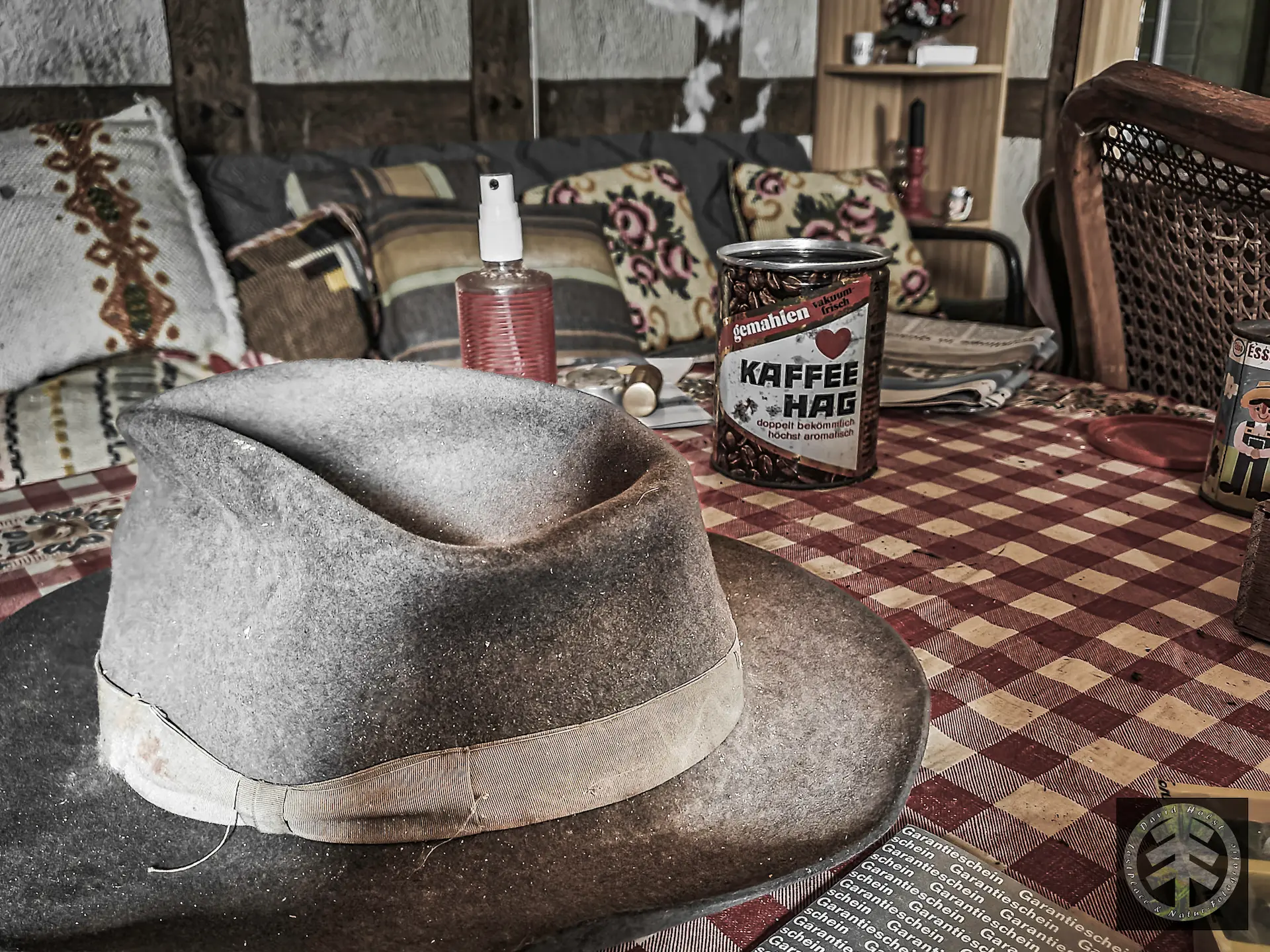 Auf dem Tisch des verlassenen Wochenendhauses liegt ein alter Hut.