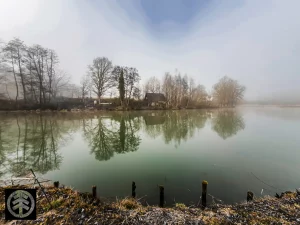 Verlassenes Wochenendhaus mit See im Vordergrund in idyllischer Atmosphäre