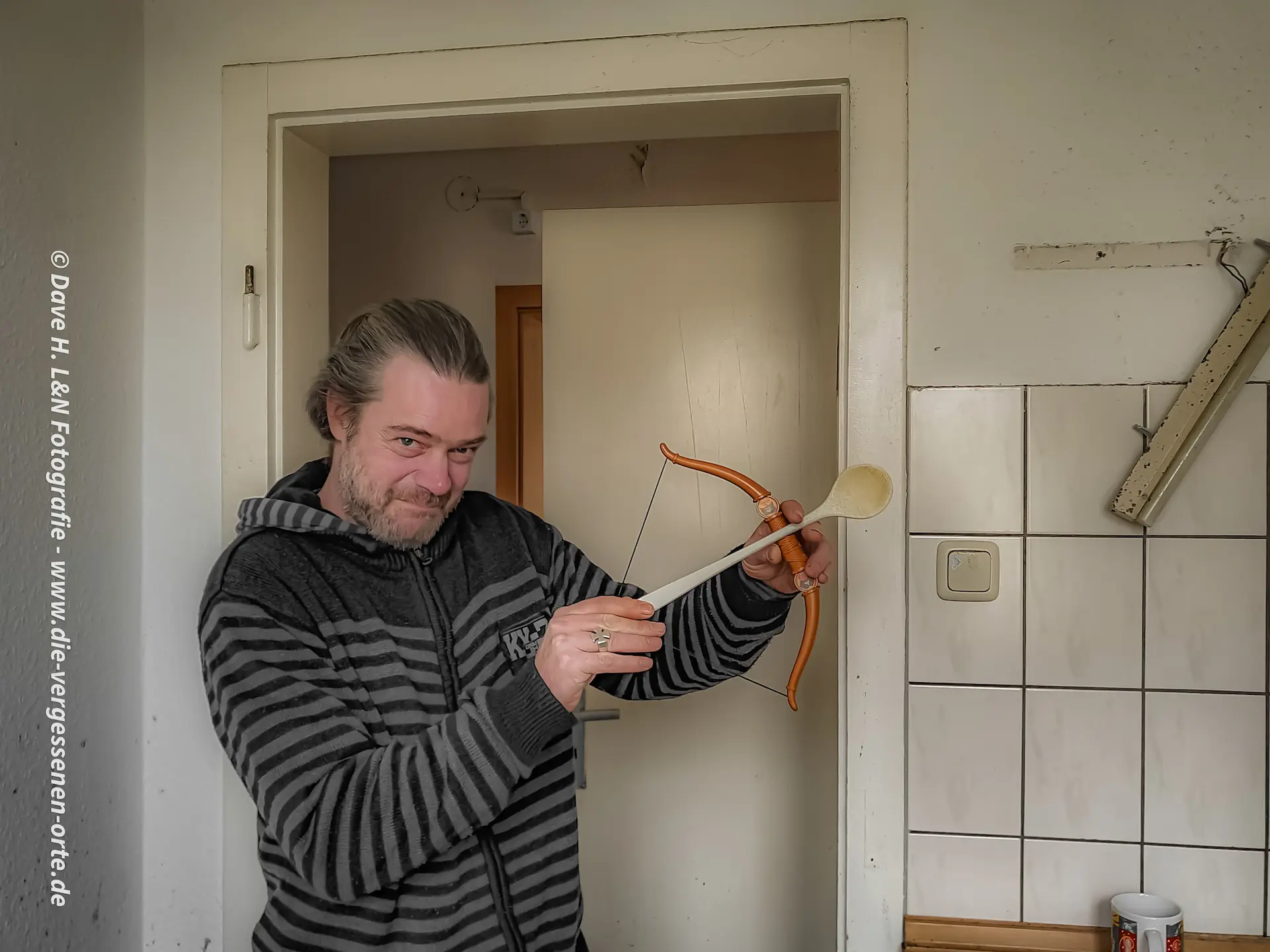 Improvisation im Lost Place: Nils mit einem Bogen und einem alten Kochlöffel aus der verlassenen Schulküche.