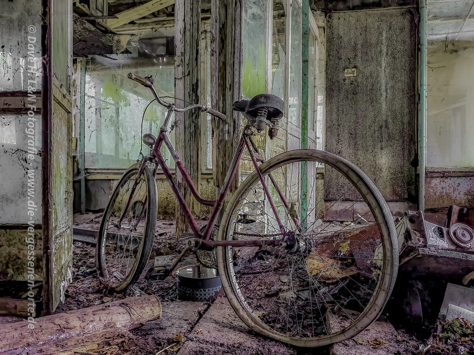 Rostüberzogenes Fahrrad ist in einem Alten Stall an einem Pfeiler angelehnt.