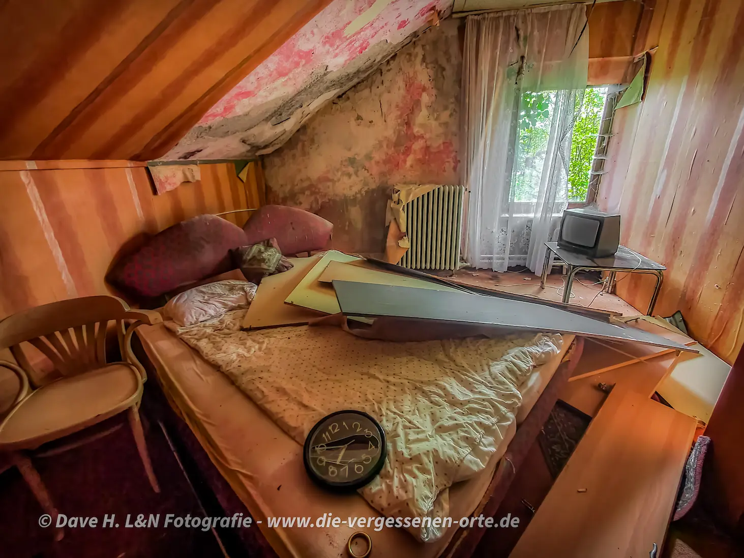 Ein mit warmen Rottönen verziertes und noch eingerichtetes Zimmer in diesem verlassenen Bordell gibt Einblick in die Vergangenheit.