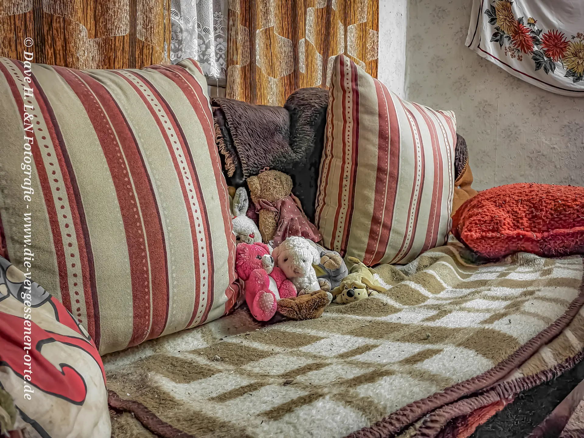 Auf dem Sofa sind die Kissen und Kuscheltiere von Vandalismus unberührt.