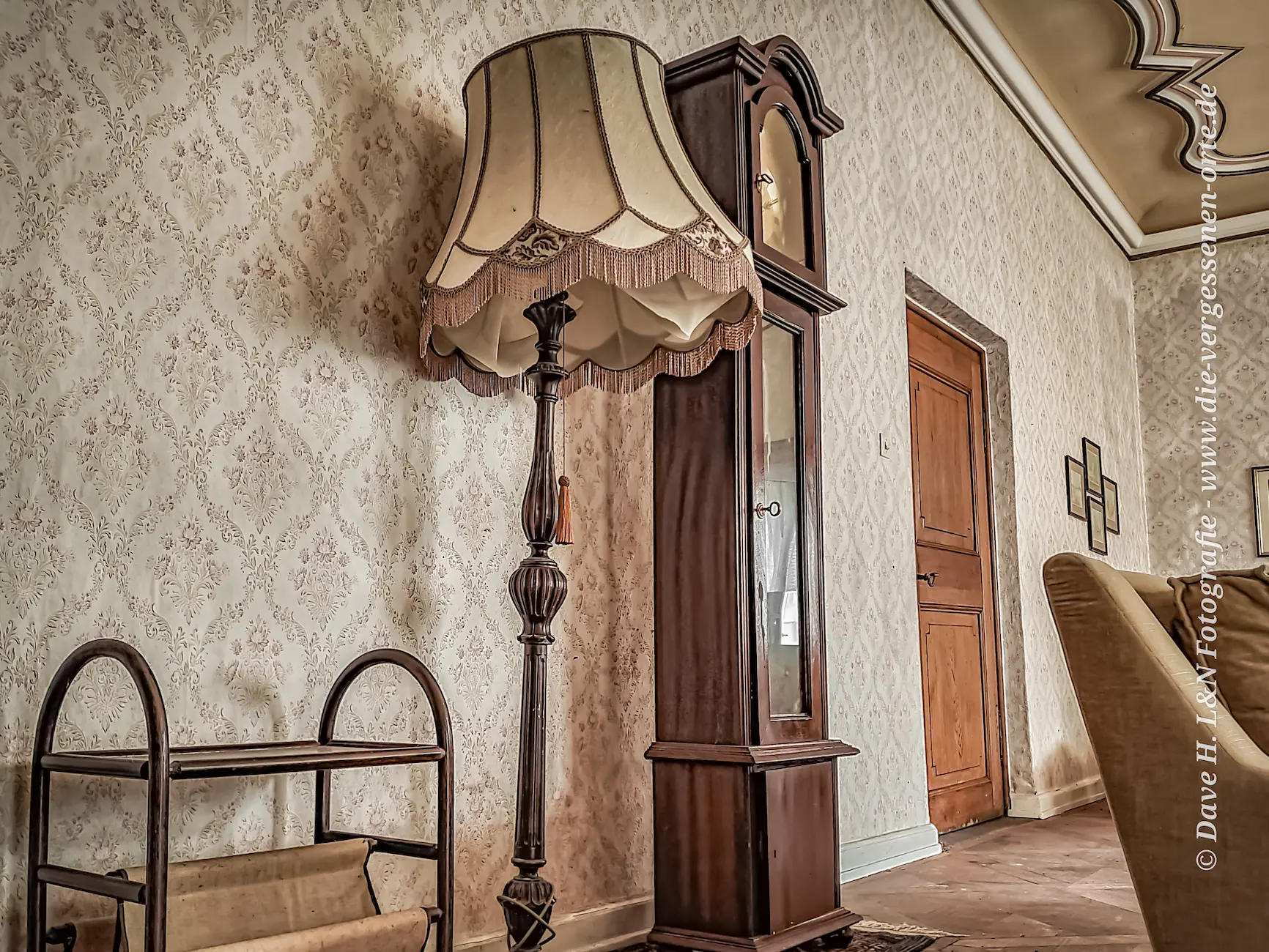 Stehlampe und Standuhr im Wohnraum des verlassenen Schlosses.