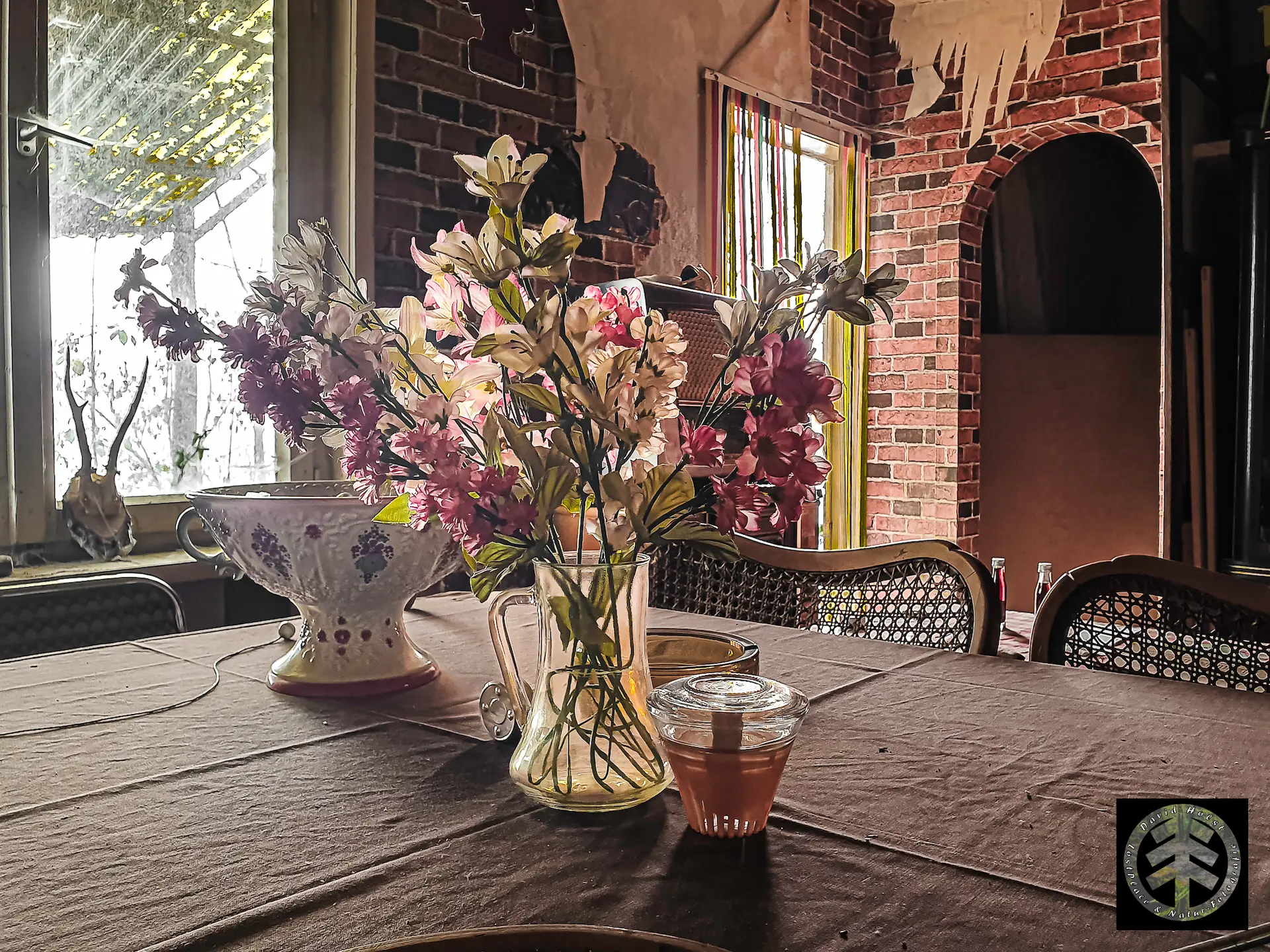 Kunstblumen auf dem Tisch eines verlassenen Hauses.