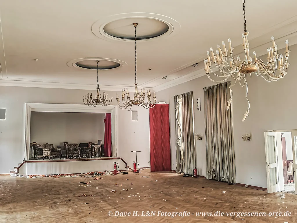 Großer Saal mit Kronleuchtern die bereits zum Teil Opfer von Vandalismus wurden.