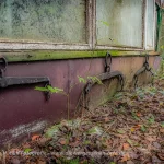 Wasserträger hängen an der Hauswand eines alten Gebäudes.
