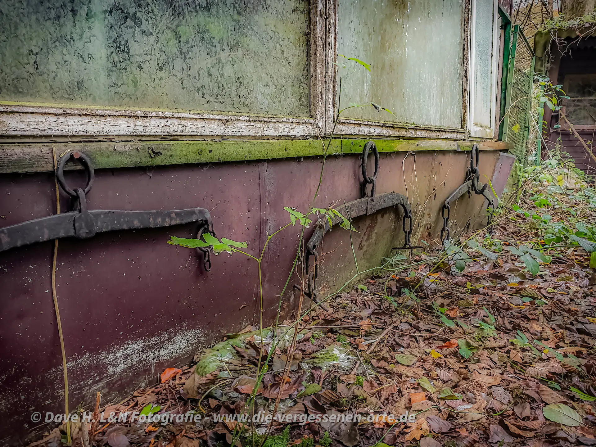 Wasserträger hängen an der Hauswand eines alten Gebäudes.